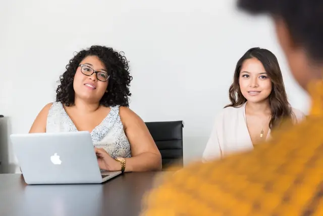 Two woman listening to someone discuss business